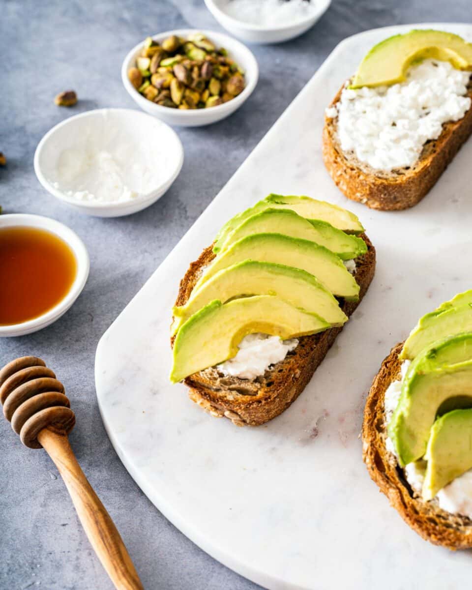 Arranging slices of avocado on toast