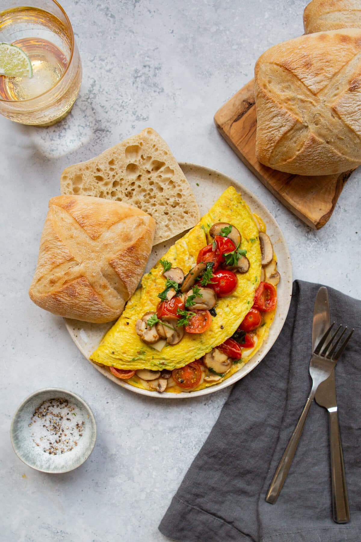 mushroom tomato omelette served with sliced ciabatta bread